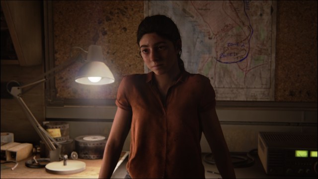 Dina in front of map in The Last of Us Part 2 Remastered.
