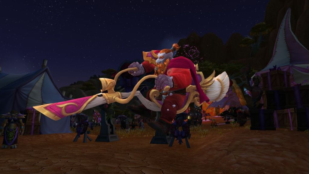 A dwarf rides a broom/motorcycle hybrid mount in front of a celebration