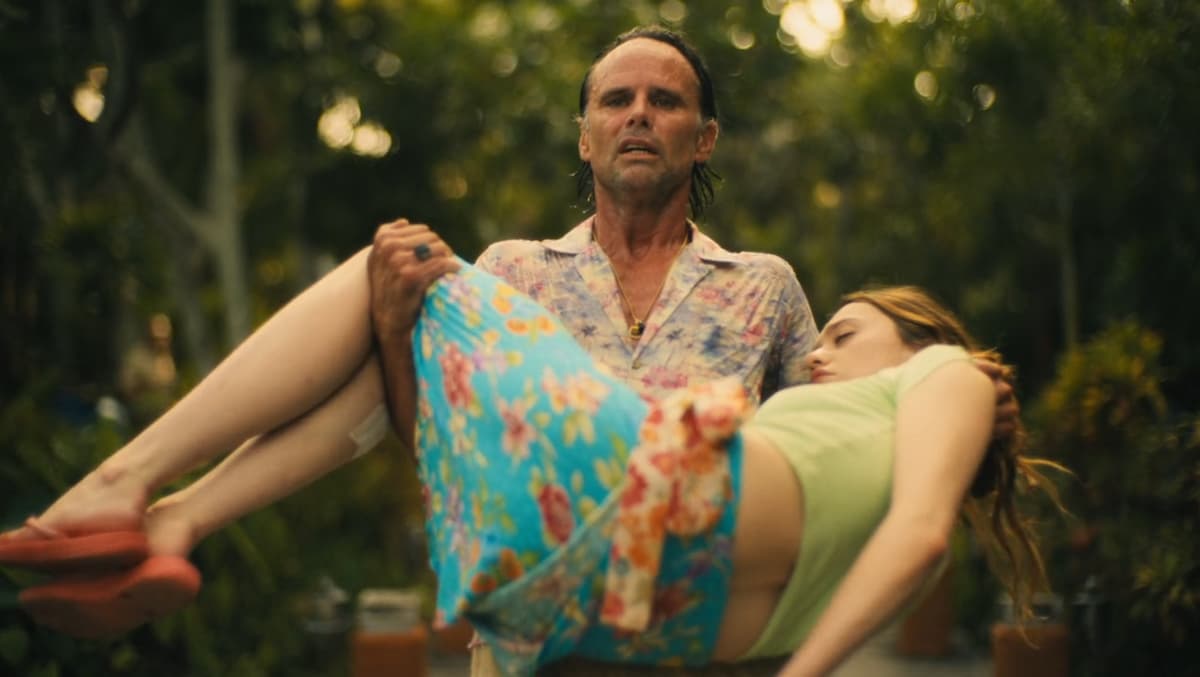 a still of a man carrying a dead woman in his arms in white lotus season 3