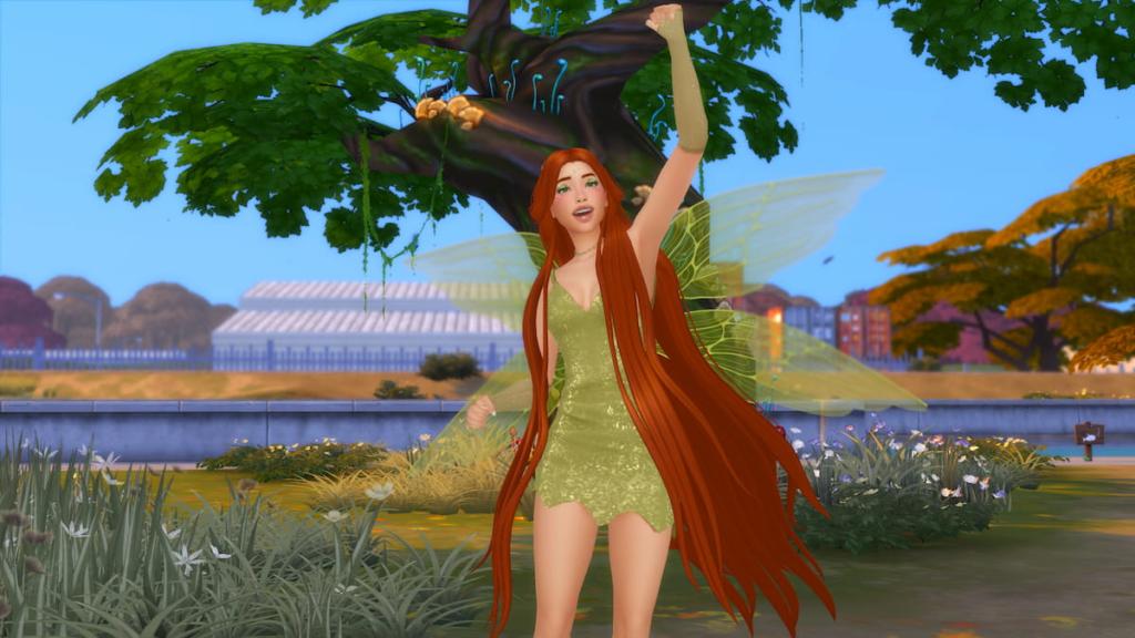 A Sim dressed as a fairy in a green dress with green wings and long orange hair jumping up in excitement while standing by a tree in The Sims 4