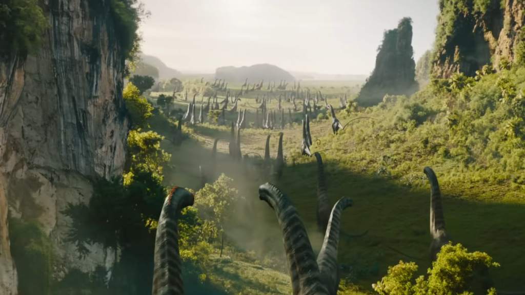 A bunch of long necked dinosaurs walking through grass in jurassic world rebirth