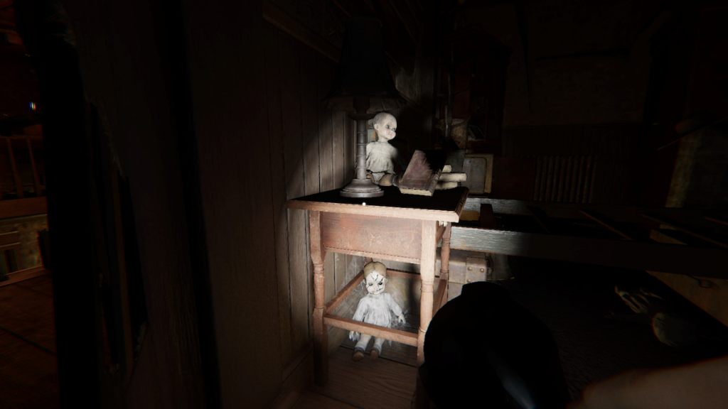 Dolls on and under an end table in phasmophobia