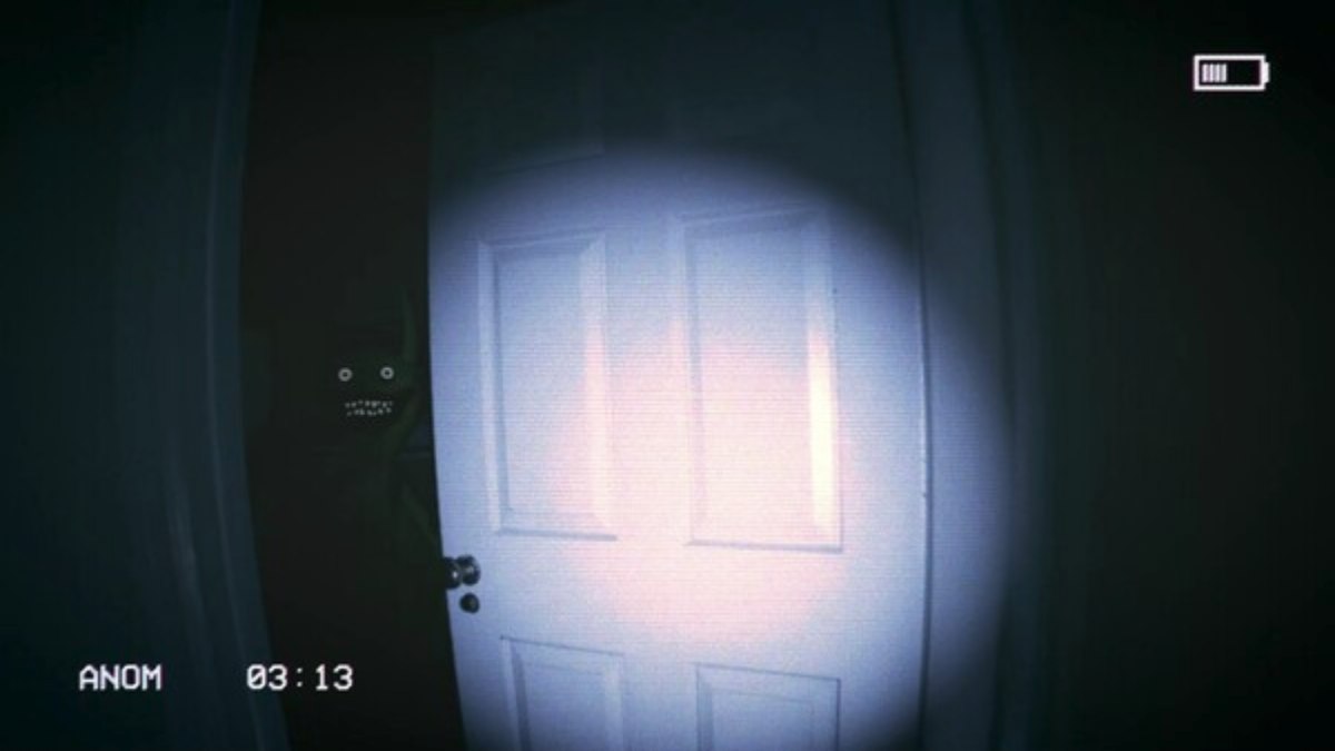 Shining the flashlight on an ajar door with the Carreteras monster peeking out