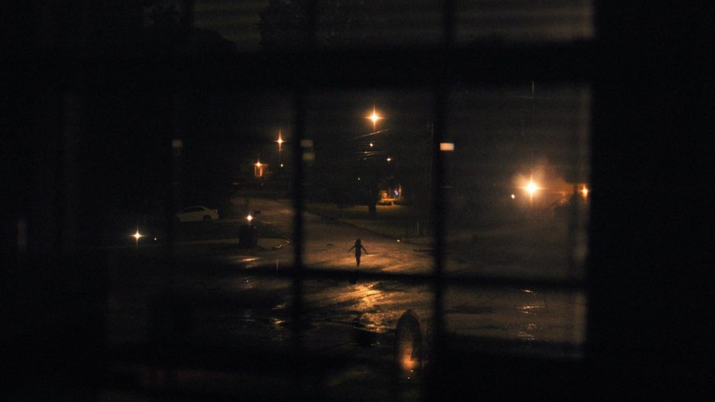 A child running with their arms out outside a window in weapons