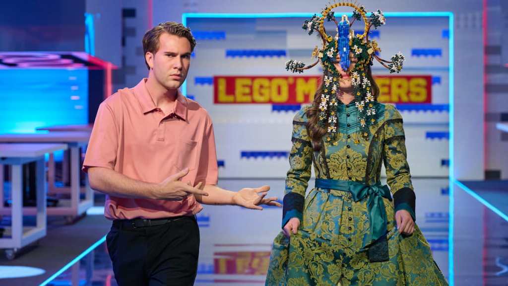 A contestant wearing a green and yellow lego mask in lego masters