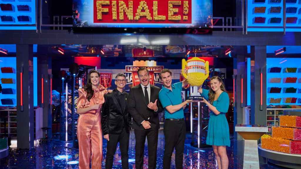 Will arnett, Jaime, and Amy posing with the winners of lego masters season 5 holding a trophy