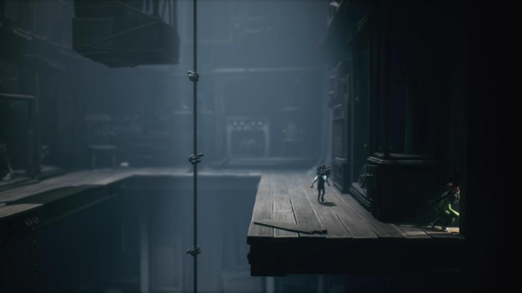 Going through a hole on the upper platform after scaling chains, ropes, and a bathtub to reach this area