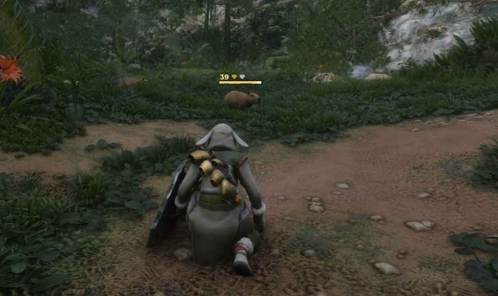 A screenshot from Enshrouded showing the player character crouching to tame a capybara in front of it. The capybara has a yellow health bar and one of two yellow hearts above it.