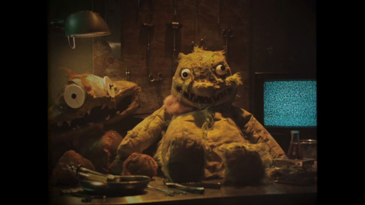 Real Outimal toys in opening cutscene sitting on workshop table with static tv behind them