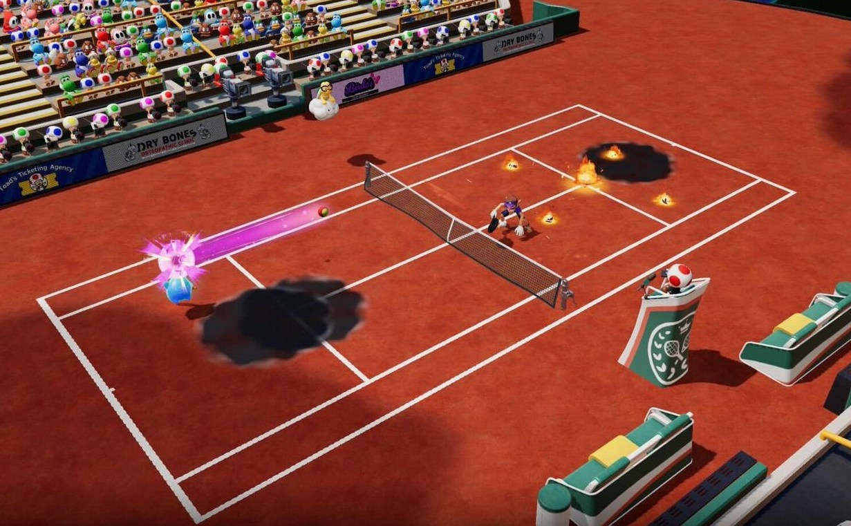 Waluigi and a blue Luma play tennis on a clay field. Fireballs and ink splatters litter the court.