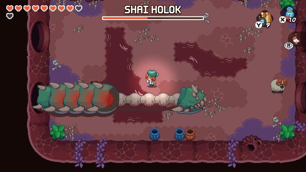 Nia stands above a giant worm  named Shai Holok that's missing half of its body.